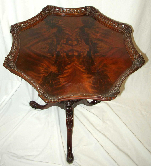 This lamp table from the late 1940s has a crotch cut mahogany veneer top and a red gum edge. Crotch cut veneer is cut from the intersection of a large branch with the trunk or the intersection of two large branches. That creates the 
